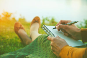 Woman ready to write with pen and notebook in hand