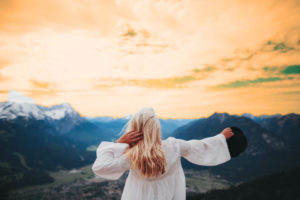 Young lady balancing near mountain and beautiful sky view.