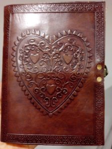 Red journal with celtic heart design to begin writing new chapters.